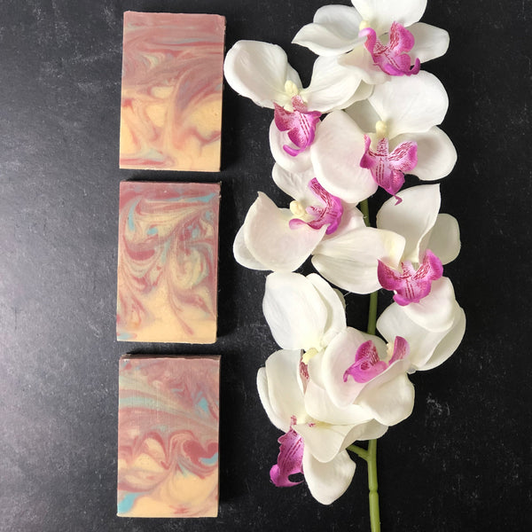 black raspberry vanilla artisan soap pictured with white orchids, bar soap, soap bar, artisan soap bar, natural soap bar, goat milk soap bar, oatmeal soap bar, dry skin soap bar